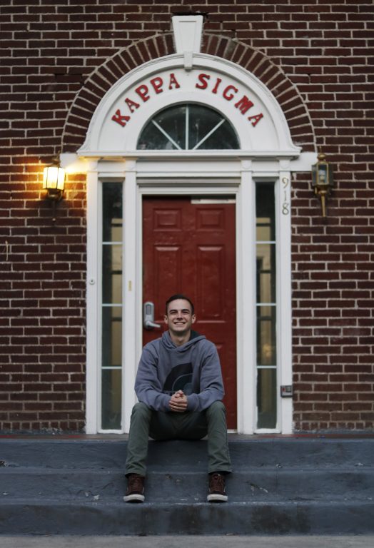 Jacob Stagge sits on the steps in front of Kappa Sigma