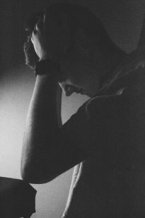 Frustrated student with his head in his hands over a table