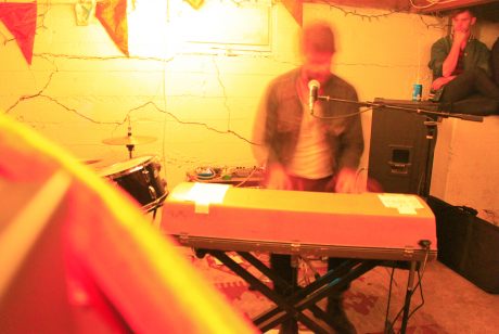 An artist playing the keyboard and singing