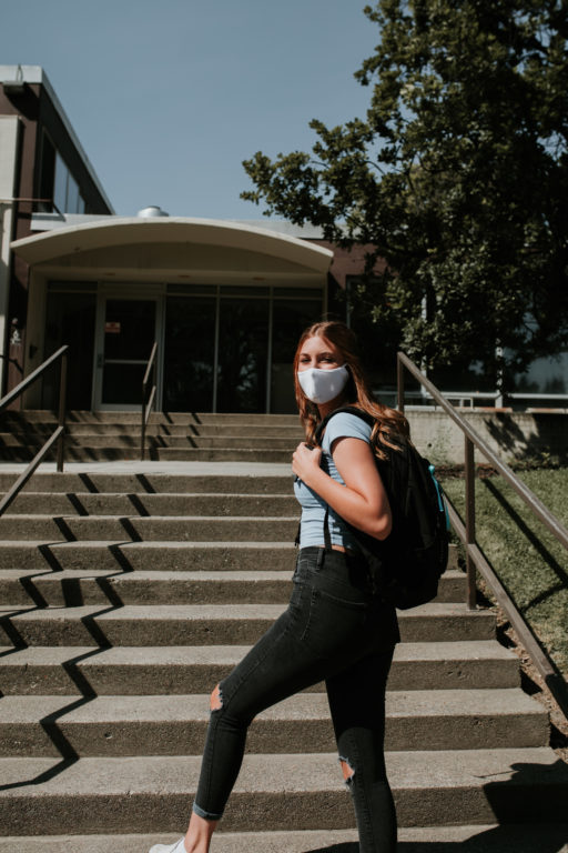 Emily Hengehold standing outside of the quarantine dorms and wearing a mask.
